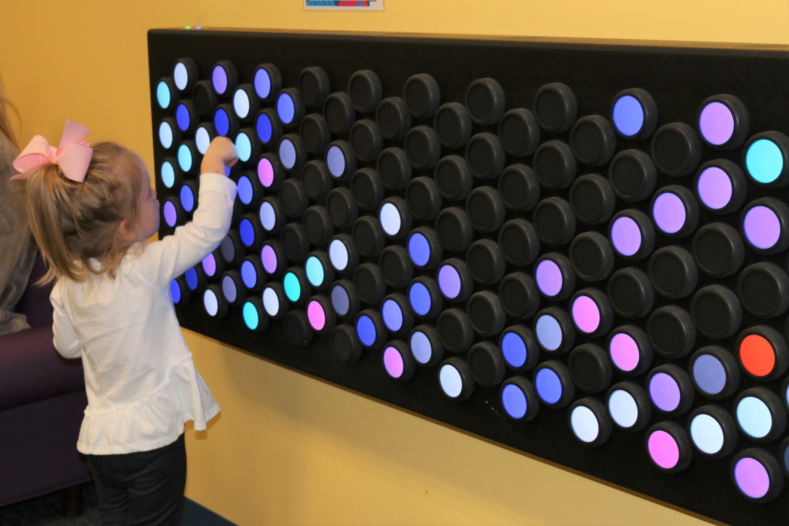 child playing with digital dot on interactive screen